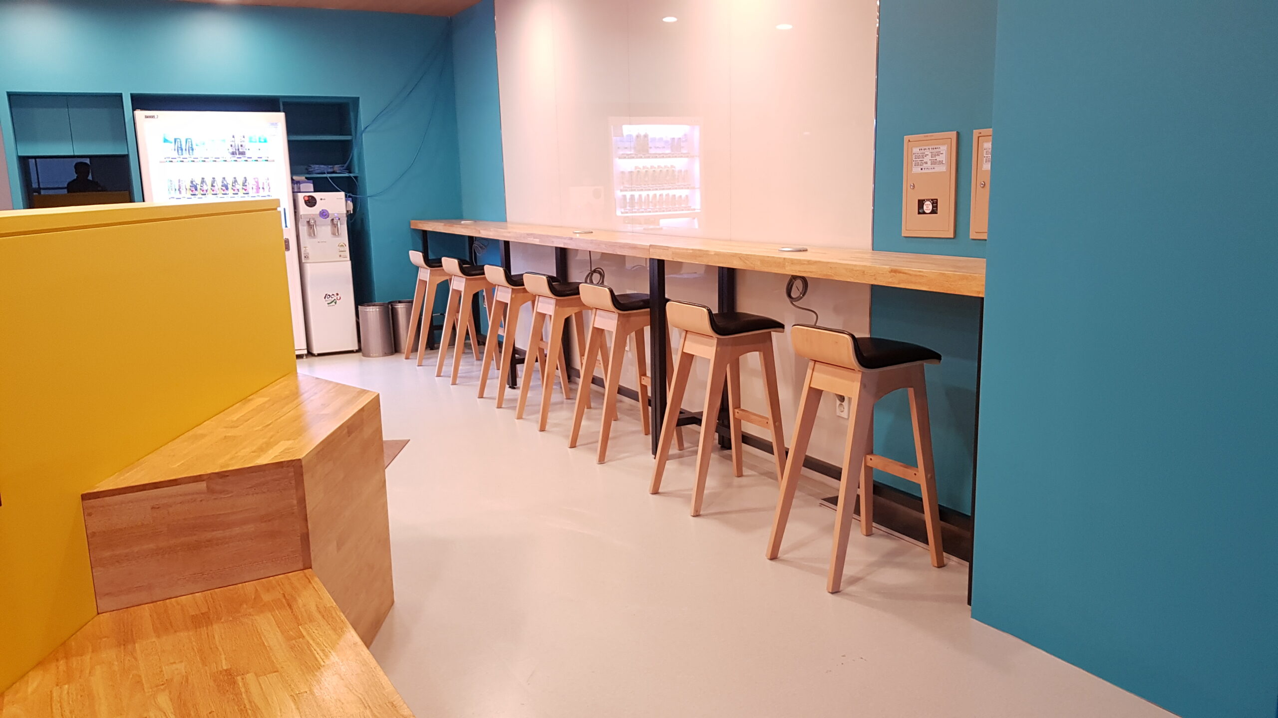 중앙대학교 스페이스 아이덴티티 — 청록색 벽과 바 테이블이 있는 라운지